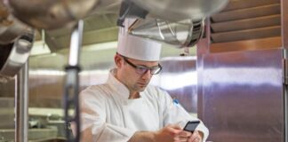 chef checking cell phone kitchen political speech Facebook