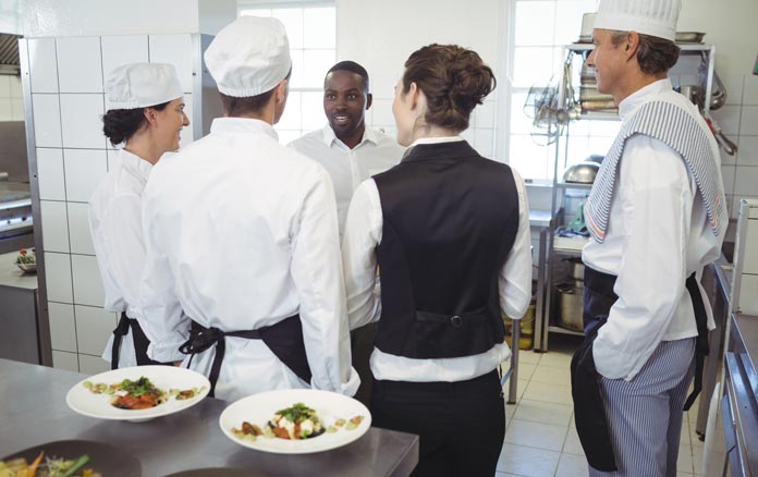 restaurant manager briefing kitchen staff anticipation