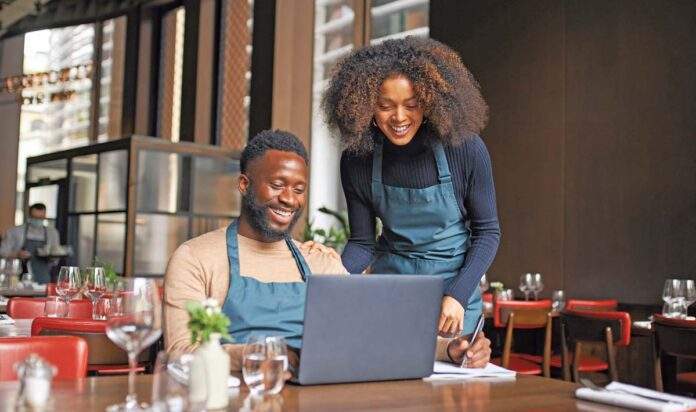 inflation impact restaurant managers working with laptop