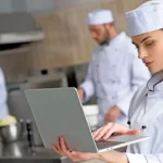 IoT chef using laptop restaurant kitchen